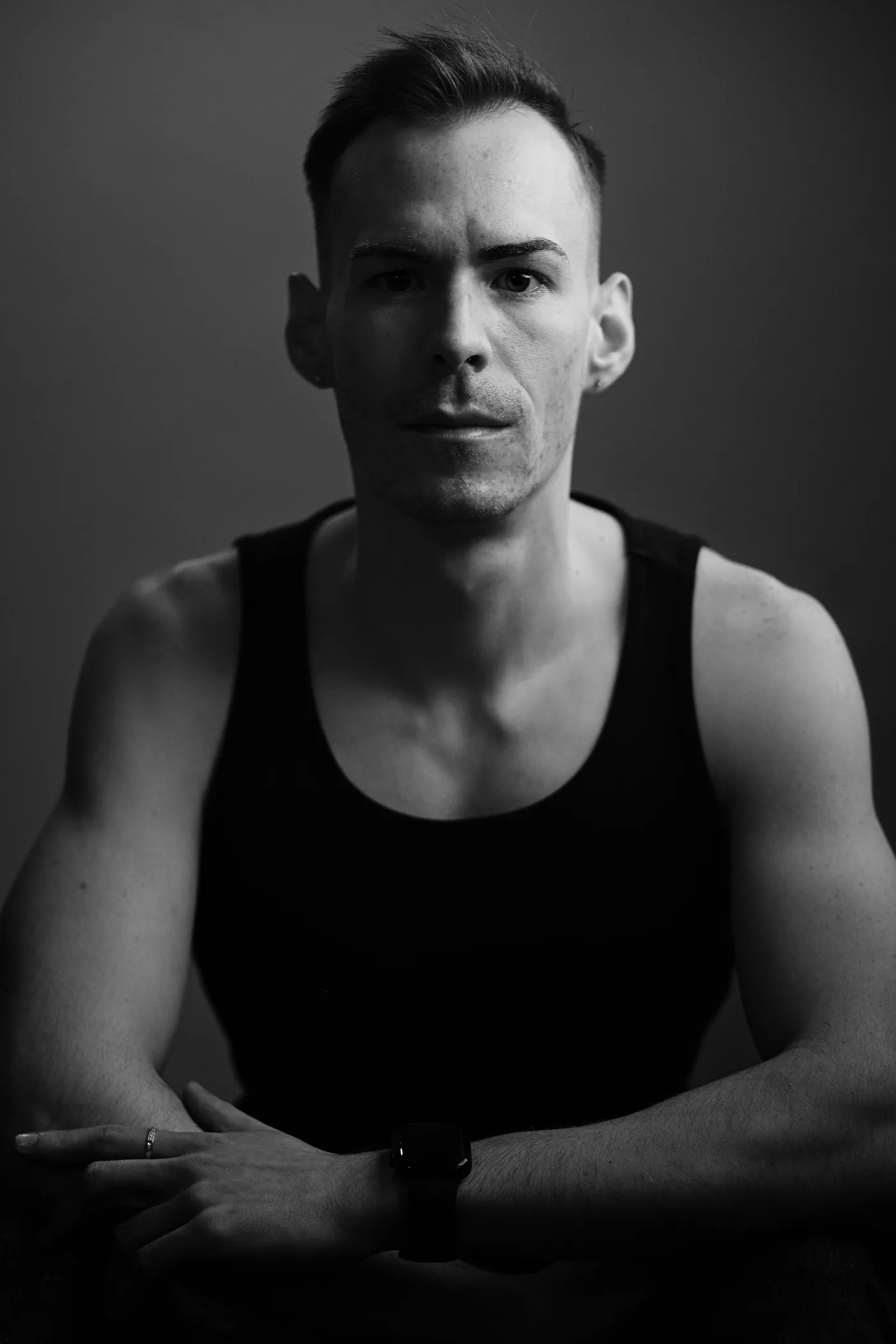 István in a dark, moody black and white portrait, arms crossed