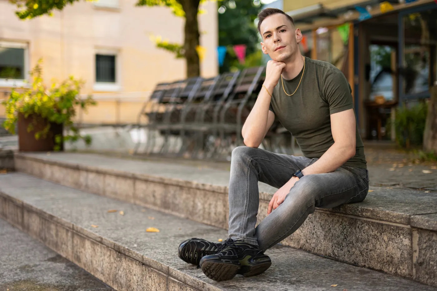 István sitting on stone steps in a town square